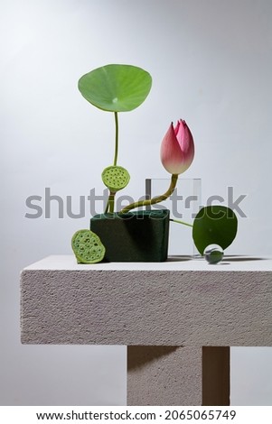 Front view of flower arrangement pink and green lotus in white background and transparent podium with blank space for advertising