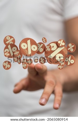 A 3D rendered sale discount symbols with a hand of a male in the background