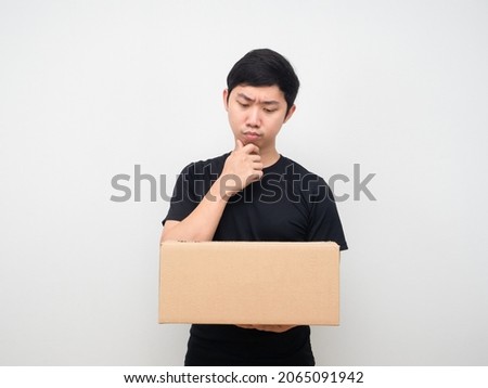 Man looking at shopping box in his hand thinking about something