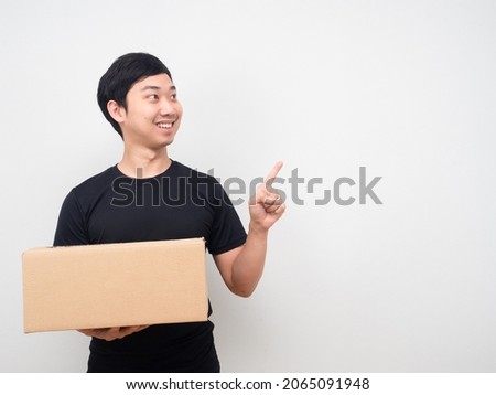 Man holding shopping box and point finger at copy space