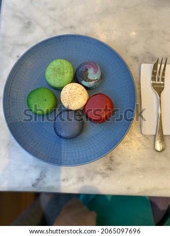 The macaroons in a plate on a table background.