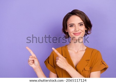 Photo of young woman happy positive smile indicate fingers empty space direct promo ads isolated over violet color background Royalty-Free Stock Photo #2065117124