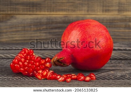 Red pomegranate on wooden background. Fruit on a wooden background. Detail for design. Design elements. Macro. Full focus. Background for business cards, postcards and posters 