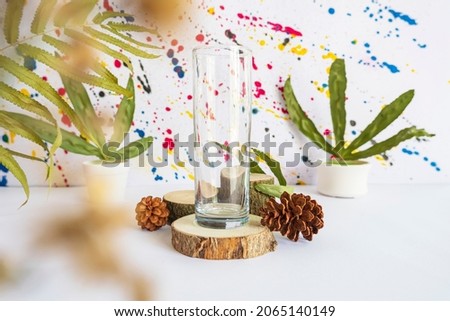 Minimalist concept displaying products. glass on logs, dried flowers, dried leaves and pine flowers on abstract background
