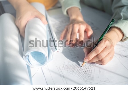 Architect working on blueprint. Architects workplace - architectural project, blueprints, ruler, calculator, laptop and divider compass. Construction concept. Blue print is fake only for stock photo.