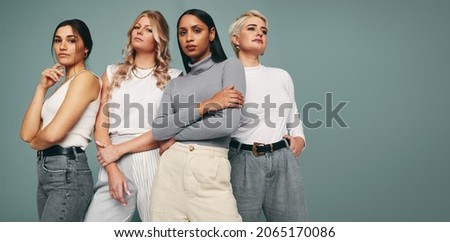 Style and confidence. Diverse group of empowered women standing together against a studio background. Self-confident female friends standing in a studio. Royalty-Free Stock Photo #2065170086