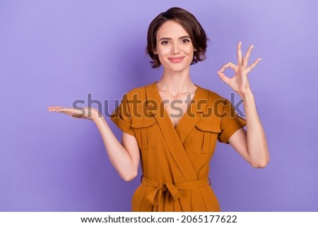 Photo of young woman happy positive smile hold hand promo product show okay feedback isolated over violet color background