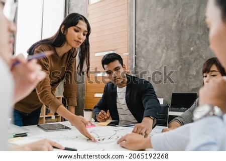 Multiracial group of young creative people in casual wear meeting brainstorming ideas about new paperwork project colleagues working together planning success strategy enjoy teamwork in small office Royalty-Free Stock Photo #2065192268