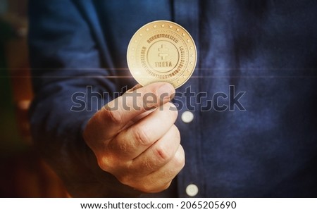 Theta Network cryptocurrency symbol golden coin in hand abstract concept. Royalty-Free Stock Photo #2065205690