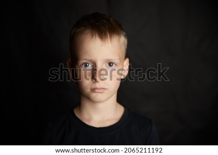 Boy blond 10 years old on a black background