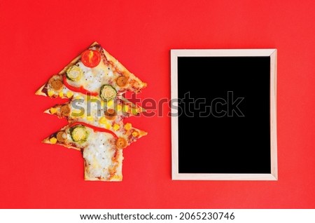 Delicious Christmas tree shaped pizza with tomatoes, vegetables and cheese on red background. Creative, funny food concept for kids. Top view, flat lay. Copy space. Template. Mock up.