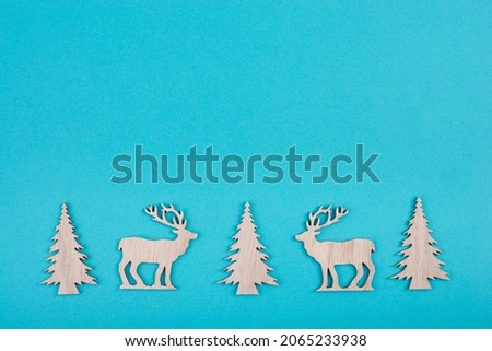 Reindeers, christmas trees, blue colored background, copy space for text, greeting card, winter backdrop
