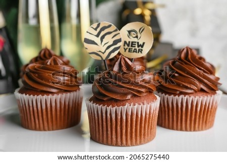 Plate with tasty cupcakes for New Year 2022 celebration, closeup