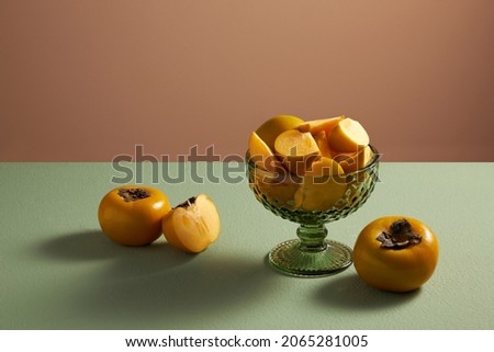 Front view of a glass of persimmon in brown background for food advertisement 