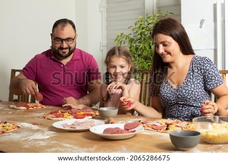 the happy young family are cooking homemade pizza