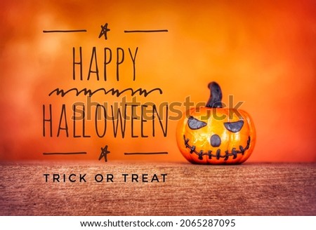 Happy Halloween card, Scary Halloween pumpkin on wooden floor over blurred orange background, Halloween decoration and card concept