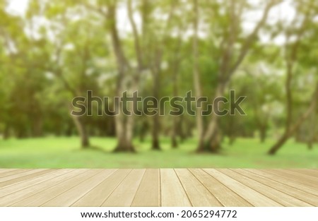 Empty top wooden table on soft blurred green nature in park for background