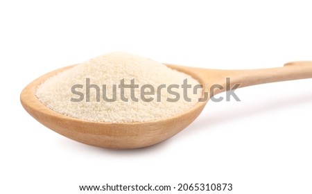 Spoon with organic semolina on white background, closeup