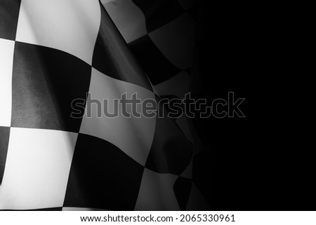 Checkered finish flag on black background, closeup Royalty-Free Stock Photo #2065330961
