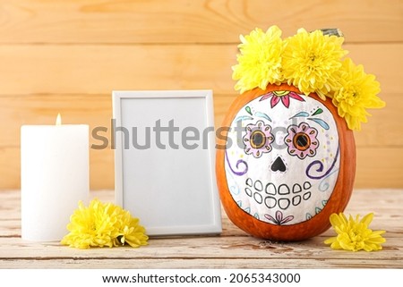 Pumpkin with painted skull on table. Celebration of Mexico's Day of the Dead (El Dia de Muertos)