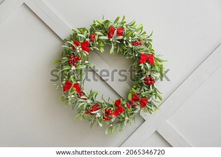 Beautiful mistletoe wreath on light wall