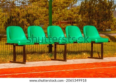 Empty plastic seats in a basketball court outdoor. Fall season.