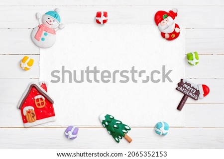 Blank paper od white wooden desk for greeting text, surrounded by Christmas decorations