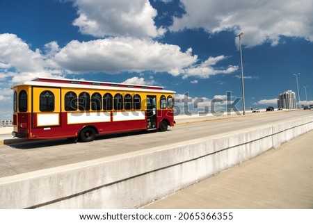 Blank billboard for your advertisement with space for text on the bus traveling across the bridge under blue sky and white clouds