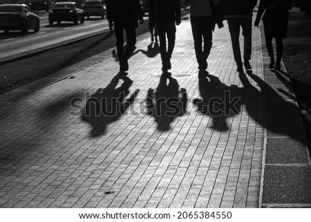 Black and white photography.  Five friends are walking around the city of Moscow.  Silhouettes of people walking on the road