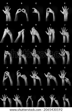 Dramatic B and W image of male hands fingerspelling BSL British sign language alphabet letters A to Z with text labels isolated against dark background Royalty-Free Stock Photo #2065430192