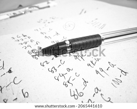 A pen on a written paper.Note writing concept.Written paper along with a pen background stock image download.Objective Time Questions answering.