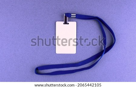 Blank white badge with blue drawstring on blue background. Pass to work, conference