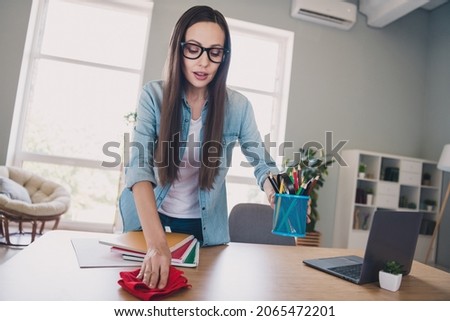 Photo of optimistic brunette millennial lady clean table wear jeans shirt spectacles work from home alone