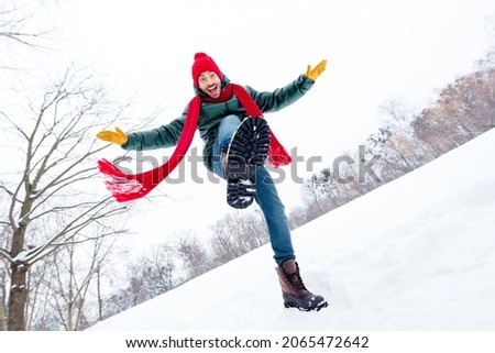 Low angle view full size photo of young excited man have fun happy positive smile walk park weekend wear hat scarf freeze outdoors Royalty-Free Stock Photo #2065472642
