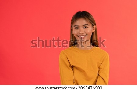 Young attractive asian girl smiling in studio