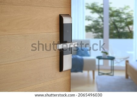 Digital Door handle or Electronics knob  for access to room security, Door wooden half opening through interior living room background, selective focus                     