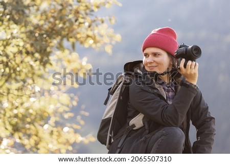a young woman taking pictures in the countryside