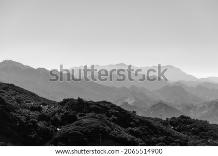 A monochrome shot of foggy mountain range layers, horizontal background Royalty-Free Stock Photo #2065514900