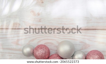 silver and pink Christmas tree balls on a white wooden background with bokeh, the concept of Christmas, Black Friday and cyber Monday. High quality photo