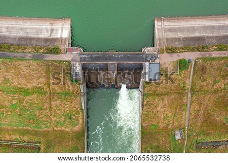 Aerial view of a large dam with a strong stream of water on the lake, in the city of Metkow Poland