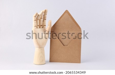 Wooden Hand and craft envelope on white background
