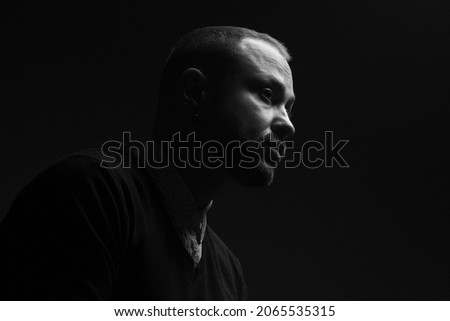 Fabulous at any age. Portrait of charismatic 40-year-old man posing over black background. Short haircut. Classic, smart casual style. Black and white studio shot