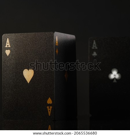 Black poker cards with gold and white embossing on a black background. Stylish composition. Minimalism. There are no people in the photo. Gambling business. Poker. Casino, nightclub, risk.