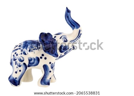 Cute Elephant Figurine Sculpture Porcelain Ceramic Isolated on white background. Cobalt Blue color is traditional folk painting. Decor for interior of premises.