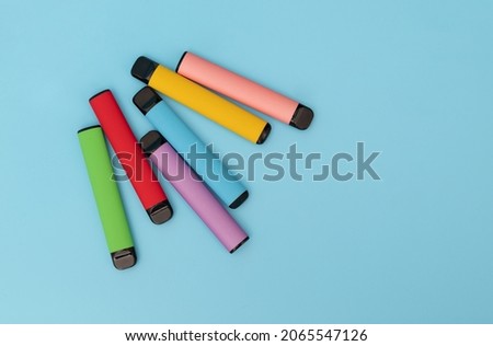 Set of colorful disposable electronic cigarettes on a blue background. The concept of modern smoking. Top view Royalty-Free Stock Photo #2065547126