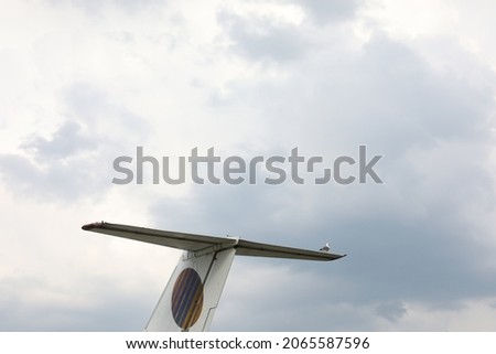 The horizontal stabilizer of a plane under a cloudy sky in the daylight Royalty-Free Stock Photo #2065587596