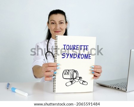  TOURETTE SYNDROME phrase on the screen. Auditor use cell technologies at office.
