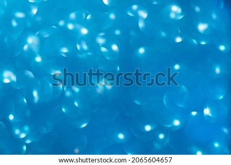Defocused christmas or party, blue glitter background with bokeh. Holiday glowing backdrop,banner or card.