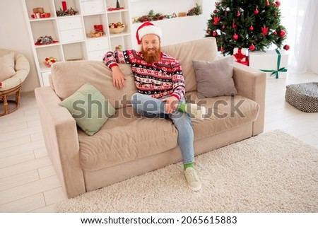 Full length body size photo bearded man chilling at home sitting on sofa near decorated xmas tree