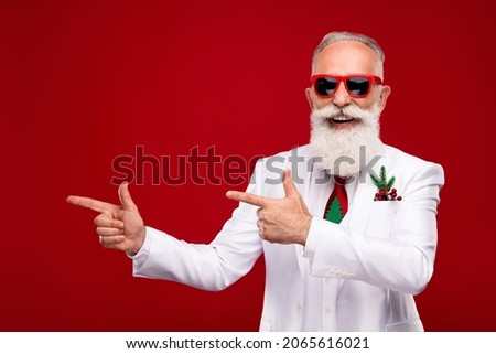 Photo of charming cheerful happy old man point finger empty space sale xmas isolated on red color background